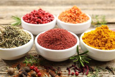 Ahşap masada farklı aromatik baharatlar, yakın plan.