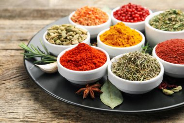 Ahşap masada farklı aromatik baharatlar, yakın plan.