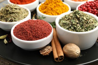 Ahşap masada farklı aromatik baharatlar, yakın plan.