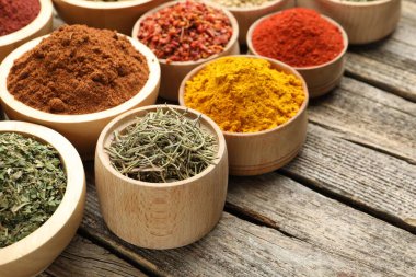 Tahta masadaki kaselerde farklı aromatik baharatlar, yakın plan. Metin için boşluk