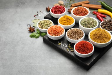 Gri masada farklı aromatik baharatlar, yakın plan. Metin için boşluk