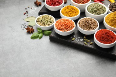 Gri masada farklı aromatik baharatlar, yakın plan. Metin için boşluk