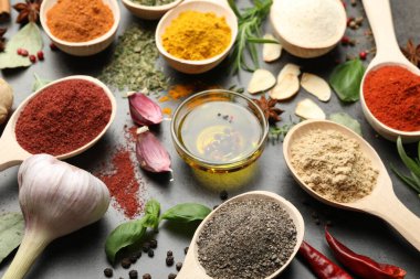 Gri masada farklı baharatlar ve yağ, yakın plan.