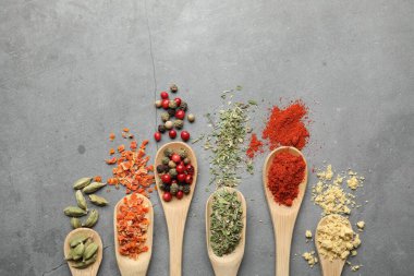 Gri masadaki kaşıklarda bir sürü farklı baharat var. Metin için boşluk