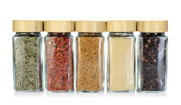 Beyaz kavanozlardaki farklı aromatik baharatlar.