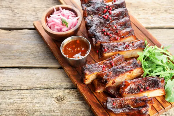 Lezzetli pirzola, soğan, sos ve roka.