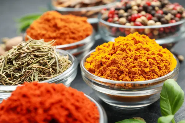 Gri masada farklı aromatik baharatlar, yakın plan.