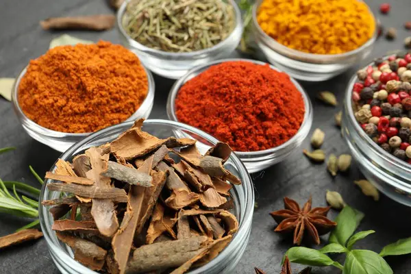 Gri masada farklı aromatik baharatlar, yakın plan.