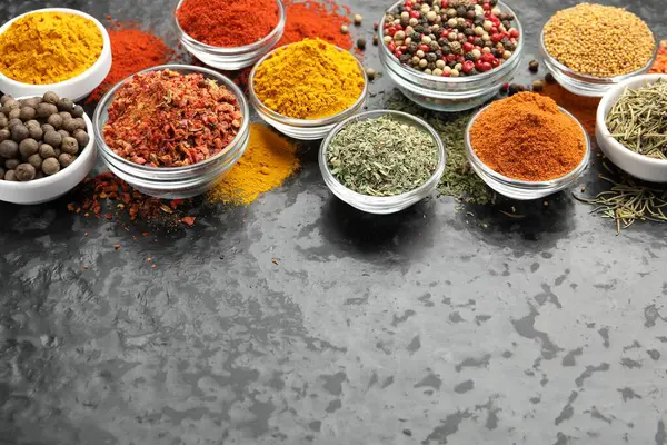 Farklı aromatik baharatlar, karanlık masada, manzaranın üstünde. Metin için boşluk