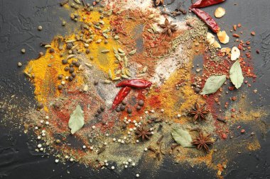 Gri masada farklı aromatik baharatlar, üst görünüm.