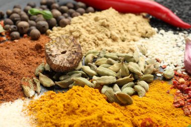 Gri masada farklı aromatik baharatlar, yakın plan.