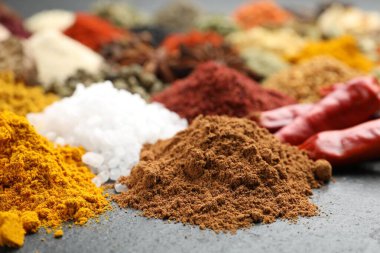 Gri masada farklı aromatik baharatlar, yakın plan.