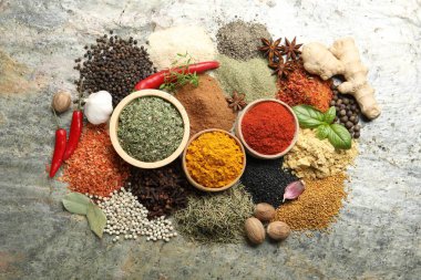Gri masanın üzerinde bir sürü farklı baharat var.
