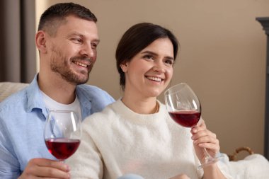 Mutlu çift evde kırmızı şarap içiyor.