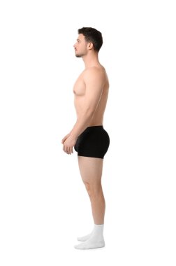 Beyaz arka planda siyah iç çamaşırlı genç adam.