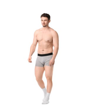 Beyaz arka planda açık gri iç çamaşırlı genç adam.