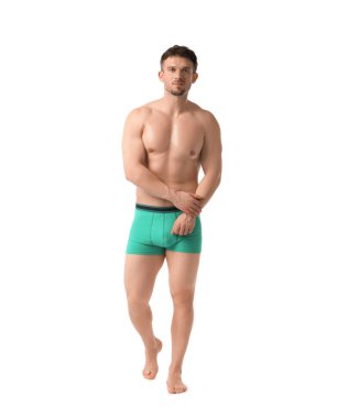 Beyaz arka planda şık turkuaz iç çamaşırlı genç adam.