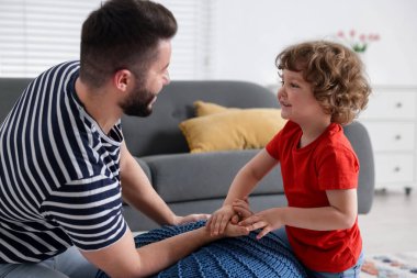 Mutlu baba oğluyla bilek güreşi yapıyor ve evde birlikte vakit geçiriyor.