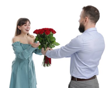 Adam beyaz arka planda sevgilisine kırmızı gül buketi sunuyor.