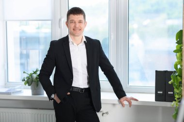 Pencerenin yanındaki yakışıklı adamın portresi.