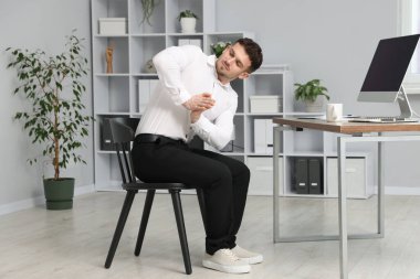 Ofiste sandalyeye uzanan yakışıklı adam.