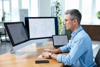 Ofisteki masada dijital çizimlerle çalışan mühendis
