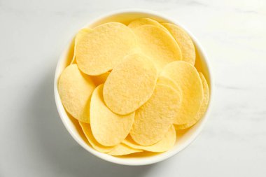 Lezzetli patates cipsleri beyaz mermer masada, üst tarafta.