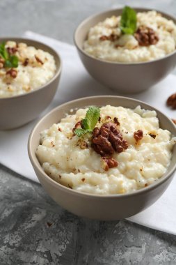 Gri masada cevizli ve naneli lezzetli sütlaç, yakın plan.