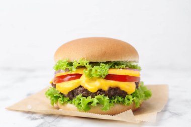 Lezzetli çizburger beyaz mermer masada, yakın plan.