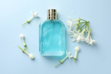 Parfüm ve yasemin çiçekleri açık mavi arka planda, düz yerde