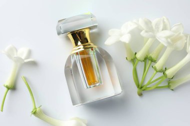 Beyaz arka planda parfüm ve yasemin çiçekleri, düz yatıyordu.