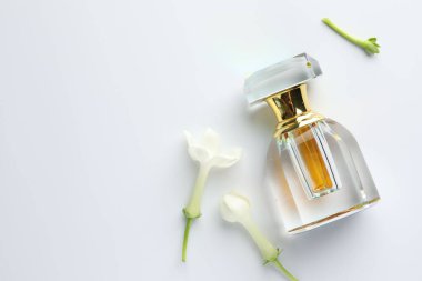 Beyaz arka planda parfüm ve yasemin çiçekleri. Metin için boşluk