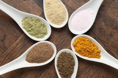 Tahta masadaki kaşıklarda farklı süper yiyecek tozları.