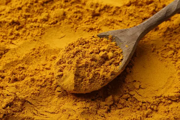 Süper gıda takviyesi. Zerdeçal tozu ve kaşık, yakın plan.