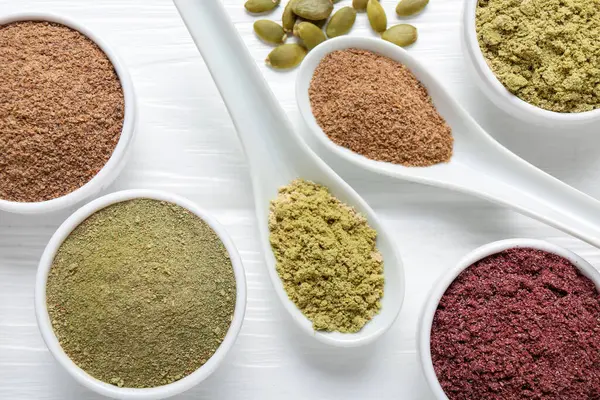 Beyaz ahşap masa üzerinde farklı süper yiyecekler, düz yatış.