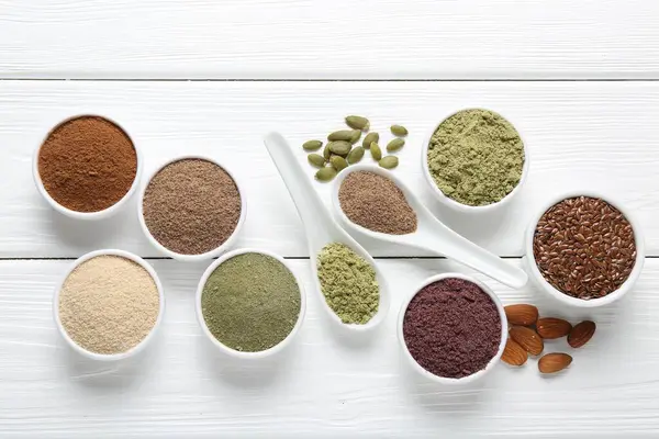 Beyaz ahşap masa üzerinde farklı süper yiyecekler, düz yatış.