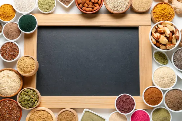 Farklı süper gıda ürünleri ve beyaz arka planda boş karatahta, düz yatak. Metin için boşluk