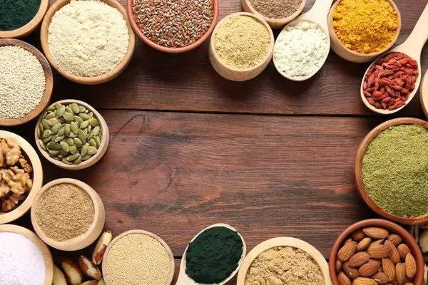 Tahta masadaki farklı süper gıda ürünlerinin çerçevesi düz. Metin için boşluk