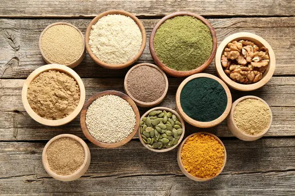 Tahta masadaki kaselerdeki farklı süper yiyecekler.