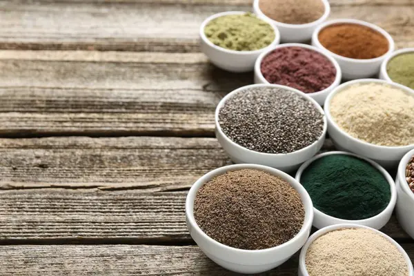 Tahta masadaki kaselerde farklı süper yiyecekler, yakın plan. Metin için boşluk