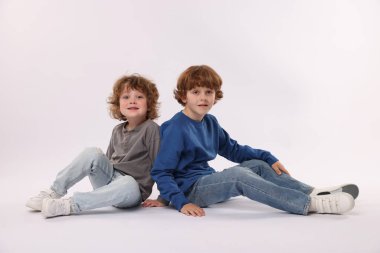 Beyaz arka planda poz veren şirin küçük kardeşler.