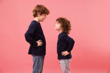 Pembe arka planda iki küçük kardeş.