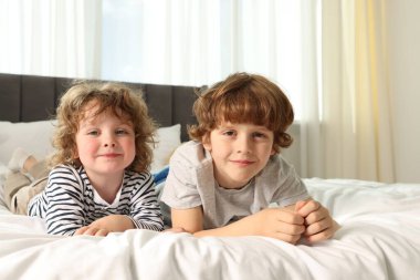 Evdeki yatakta yatan sevimli küçük kardeşler.