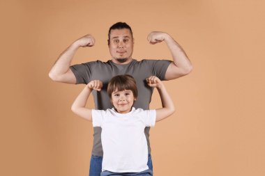 Babası ve oğlu bej arka planda.