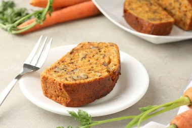 Açık gri masada fındıklı ve sebzeli ev yapımı havuçlu kek, yakın plan.