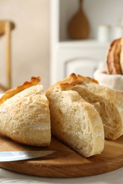 Taze pişmiş ekmek ve bıçağı masaya koyun, yakın plan.