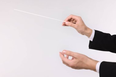 Açık gri arka planda copu olan kondüktör, yakın plan. Metin için boşluk