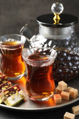 Lezzetli Türk çayı ve zevki siyah masada, yakın plan.