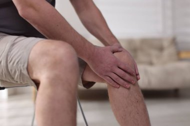 Evinde diz ağrısı çeken bir adam, yakın plan.