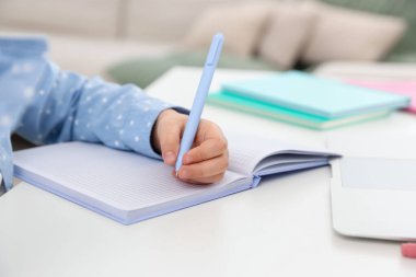 Küçük kız ev ödevlerini içeride yapıyor, yakın plan.